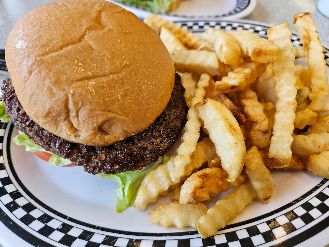 Plates on a red table at Courtesy Diner — checkered-rim dishes and condiments.